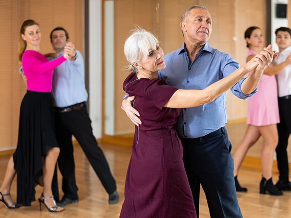 Parelles ballant en una sala de ball.